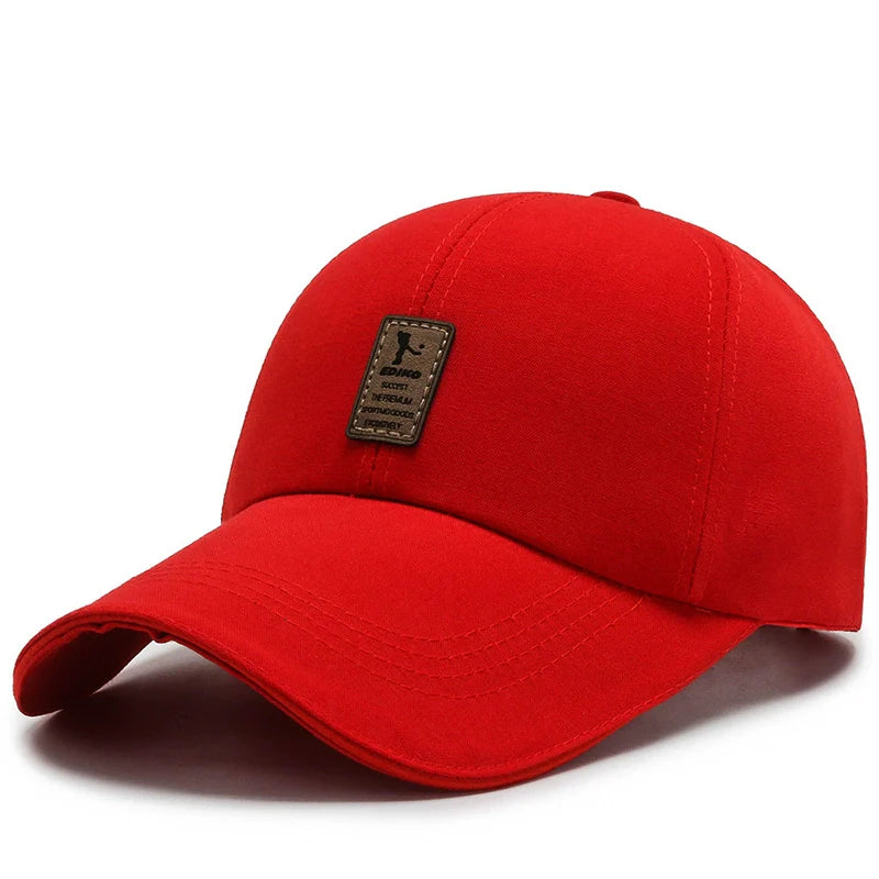 Red cotton baseball cap with curved brim and brown patch on front