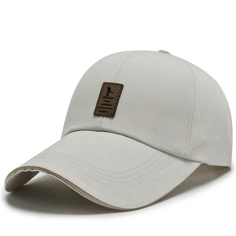 Beige cotton baseball cap with curved brim and front leather patch detail