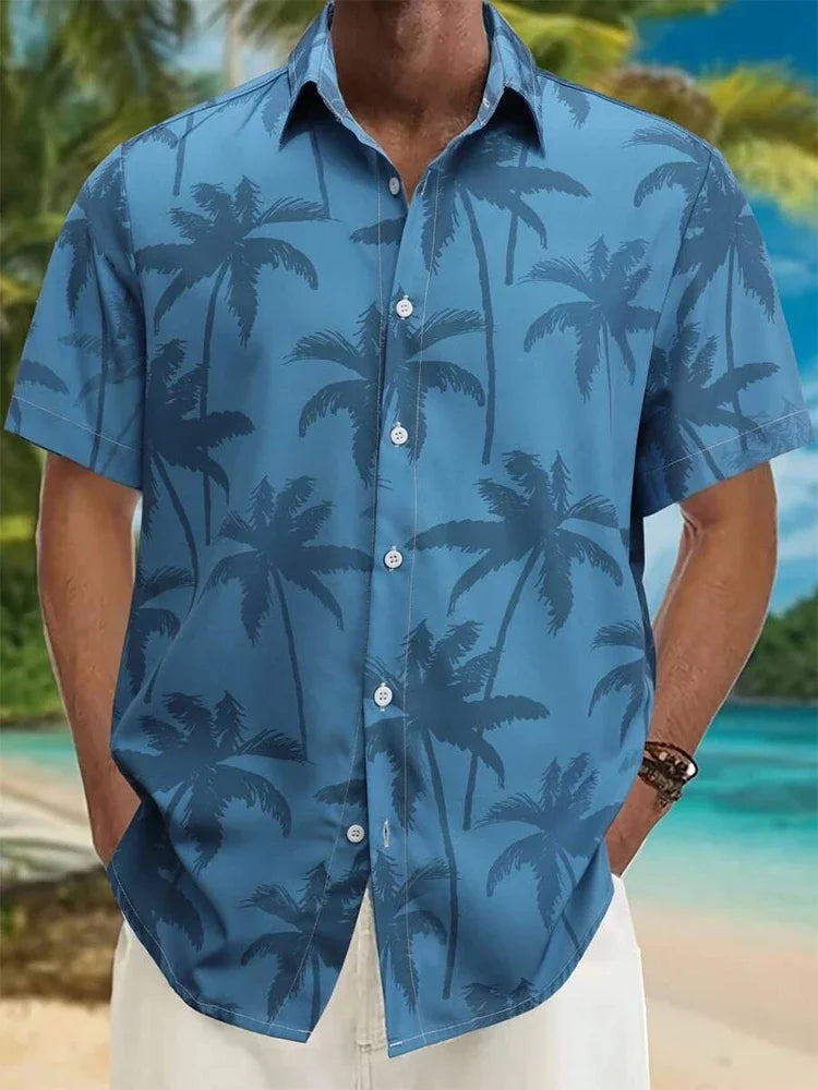 Blue short sleeve button-up shirt with palm tree print, worn on a tropical beach