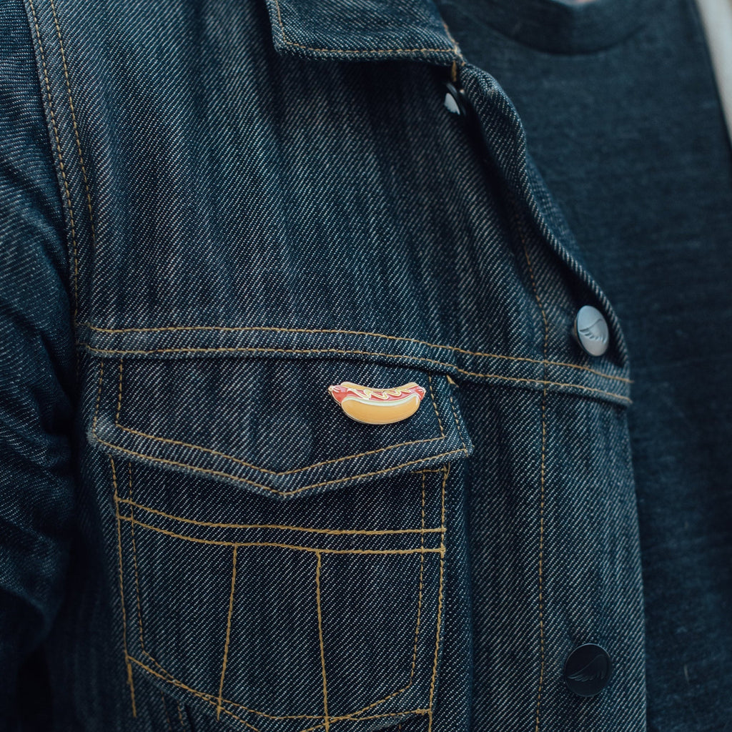 Hot dog enamel pin on denim jacket pocket
