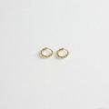 Pair of small gold twisted hoop earrings on a white textured background