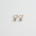 Gold hoop earrings with oval dalmatian jasper stone charms on white background